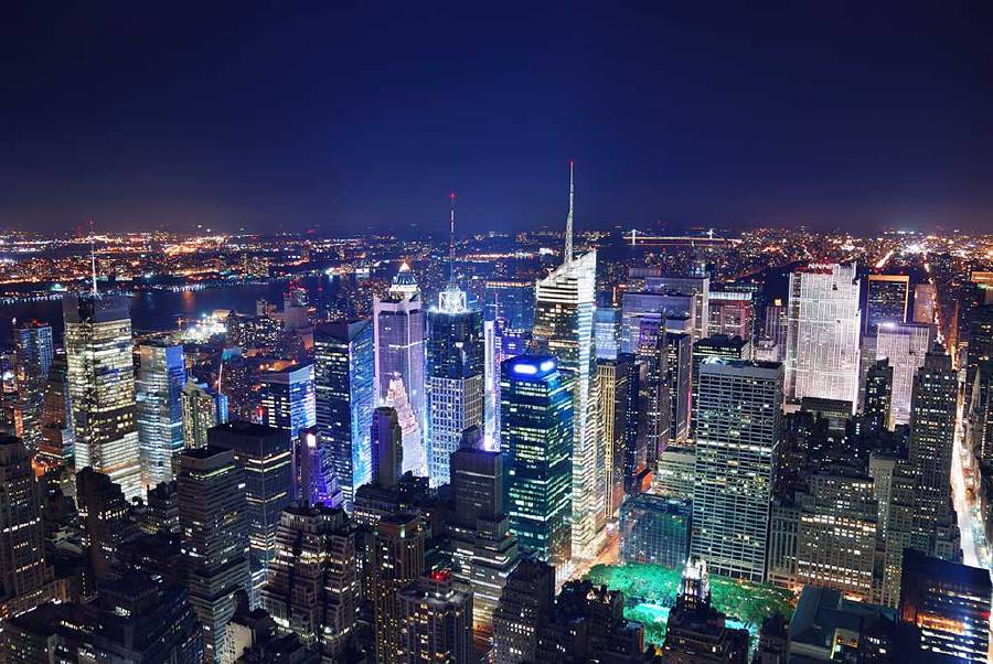 Aerial view of skyscrapers at night around Times Square, in Midtown Manhattan, New York City.